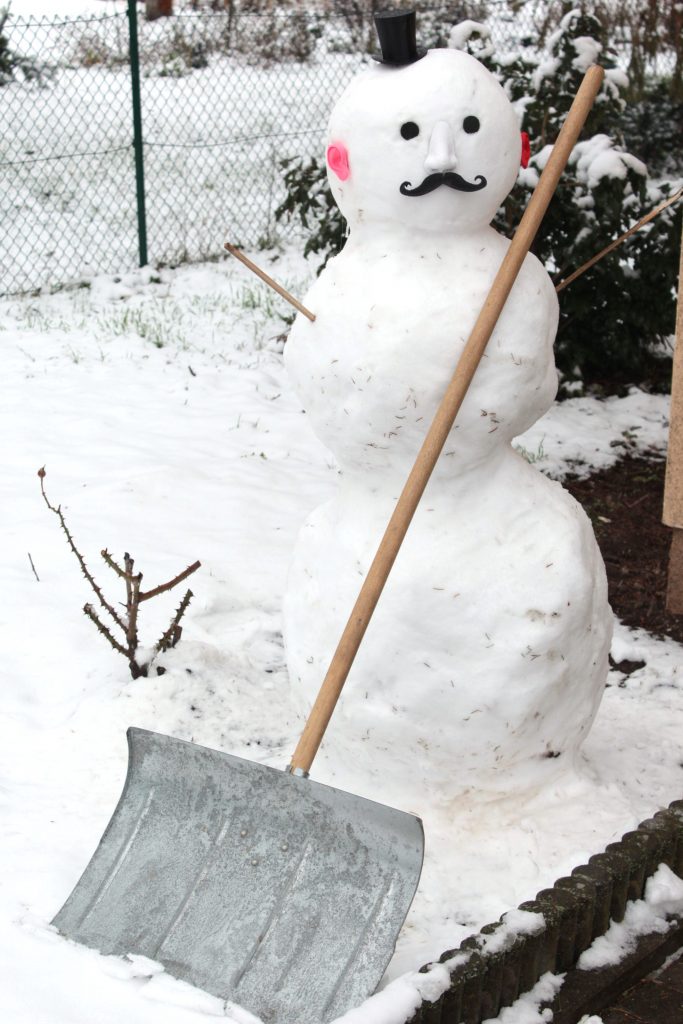 Schneemann mit Schneeschippe
